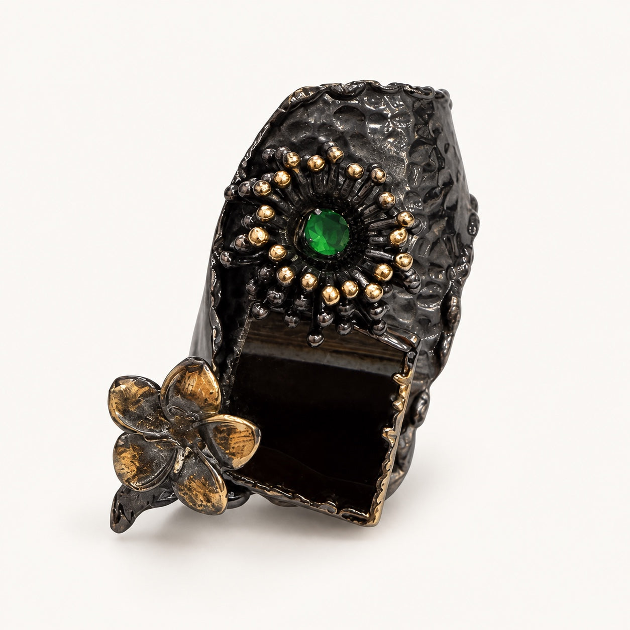 Anello color canna di fucile, vista frontale con rosone verde, dettaglio rettangolare scuro e fiore.