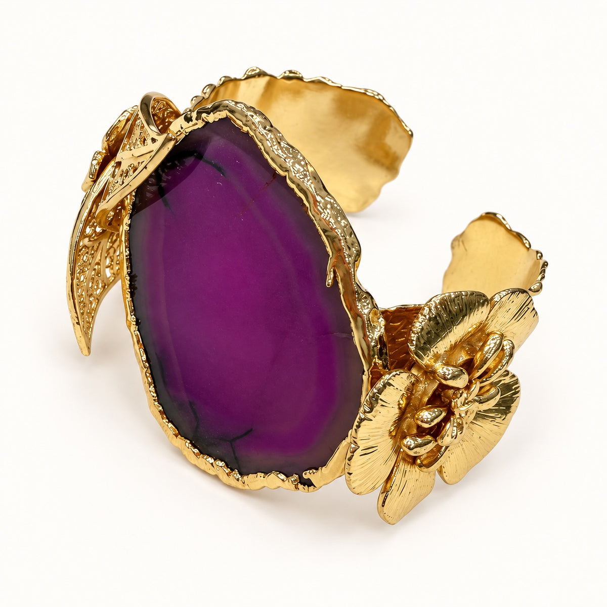 Bracciale regolabile PHILO P con elemento viola e grande fiore color oro, vista frontale a tre quarti.