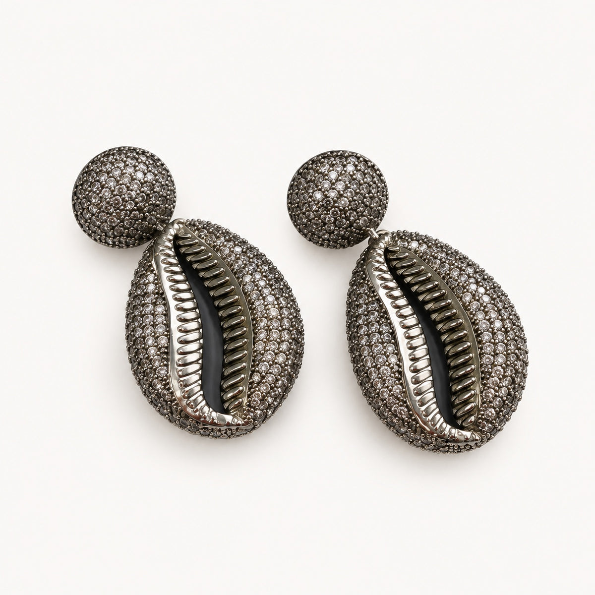 Coppia di orecchini pendenti a conchiglia color argento con elementi superiori tondi e piccoli dettagli brillanti.