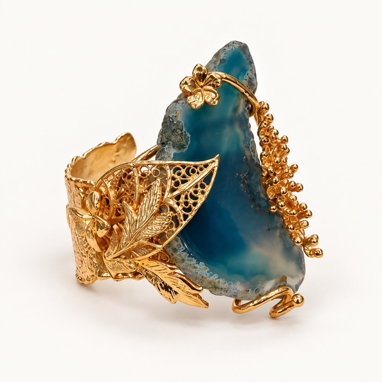 Dettaglio del bracciale blu PHILO P con foglie traforate, elementi floreali e finitura color oro.