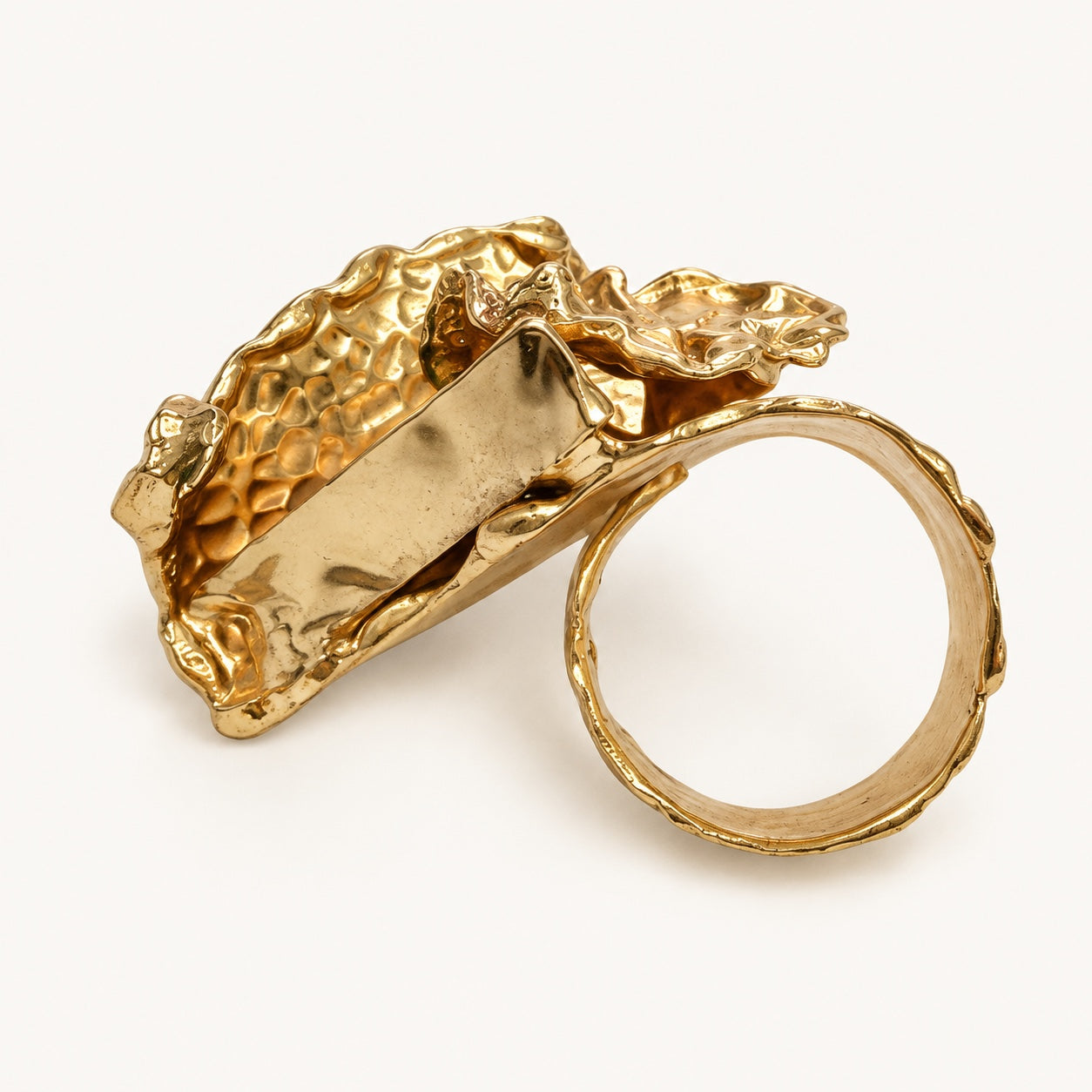 Retro dell’anello con foglia color oro, con fascia circolare e attacco della parte decorativa.