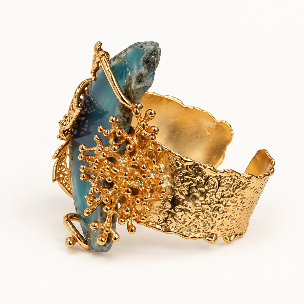Vista laterale del bracciale PHILO P blu, con fascia aperta dall’effetto martellato e decorazione ramificata color oro.