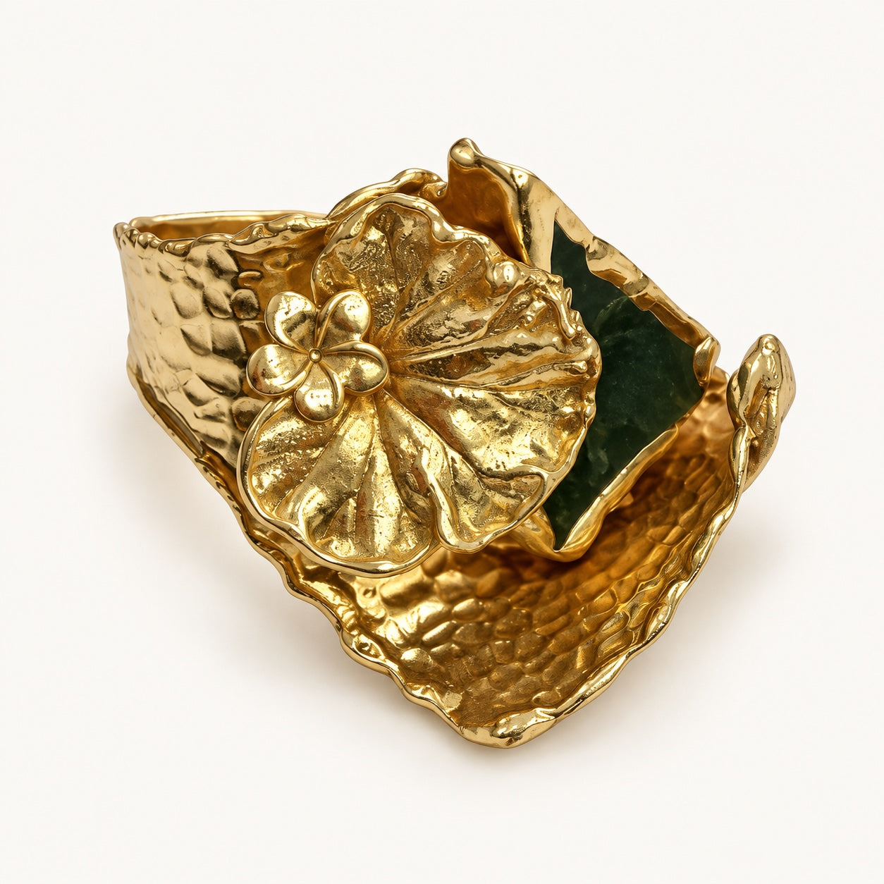 Dettaglio dell’anello color oro e verde visto dall’alto, con venature della foglia e superficie martellata.