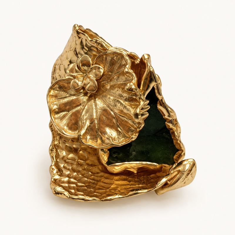 Anello color oro e verde, vista frontale con grande foglia venata e piccolo fiore.