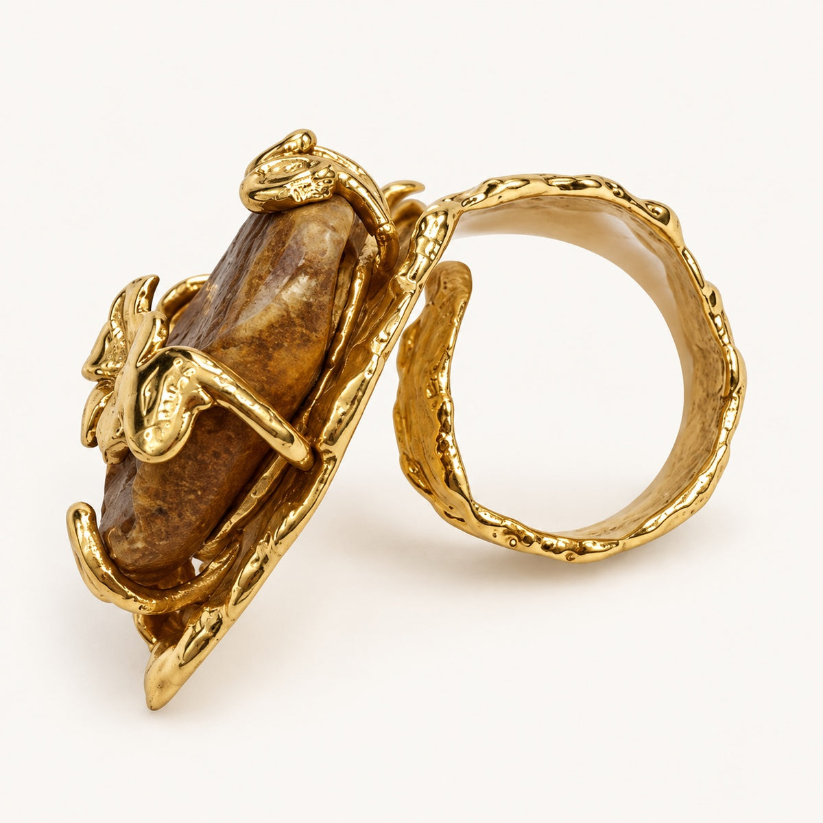 Profilo e interno dell’anello floreale color oro e marrone, con fascia curva e dettaglio centrale visto di lato.